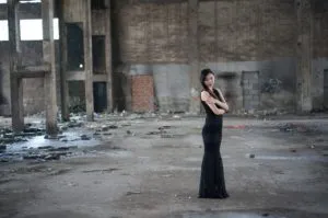 Kobieta w czarnej sukience w postindustrialnym miejscu